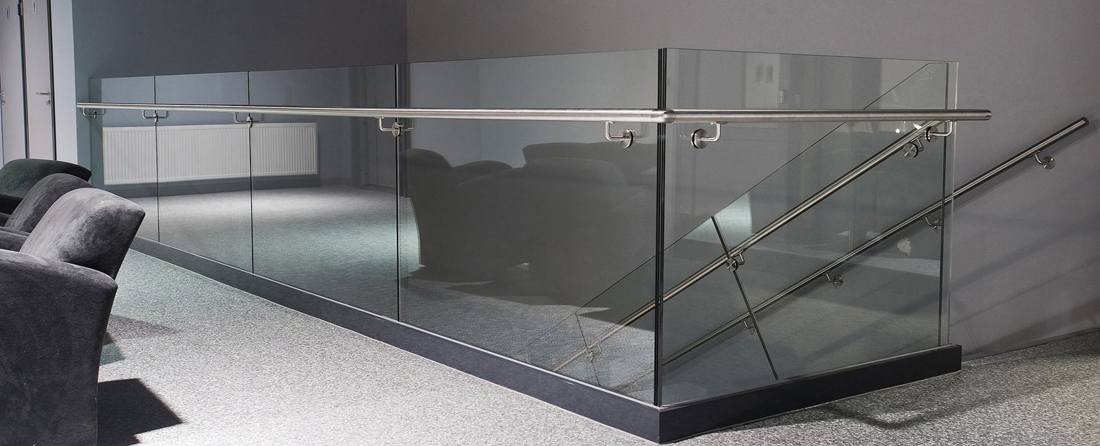Frameless glass balustrade with stainless steel handrail in a modern interior